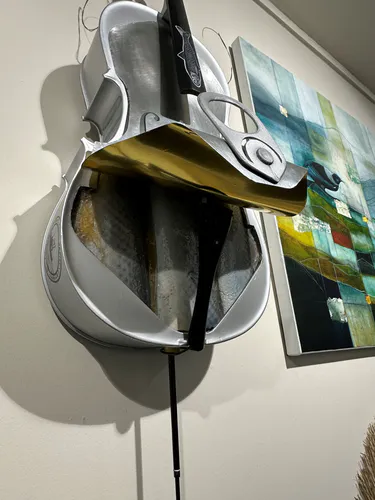 A  contemporary sculpture of a metal Cello with an open Sardine can base close up by New Zealand artist Bruce Rule, available at The Little Gallery Whangamata